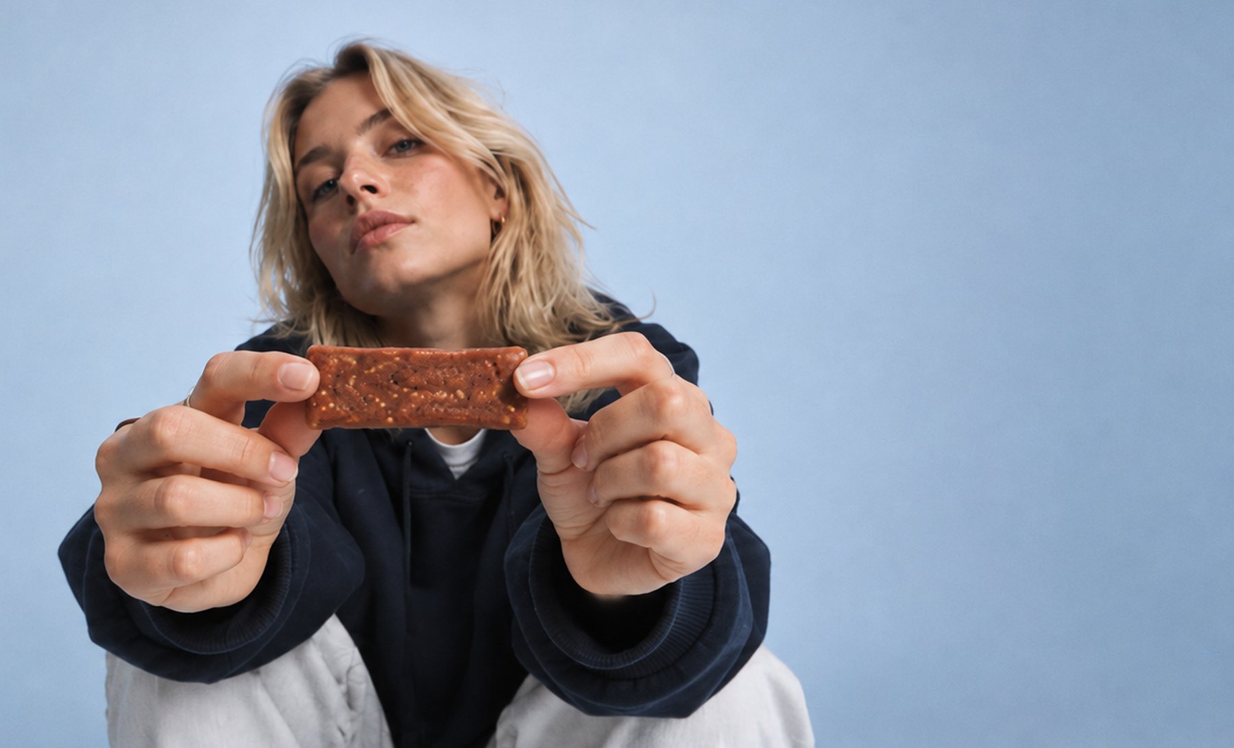Woman holding out a Benefeat bar towards the camera